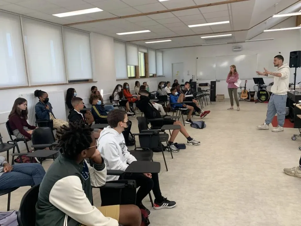 Un groupe en atelier d’écriture slam, penché sur ses feuilles