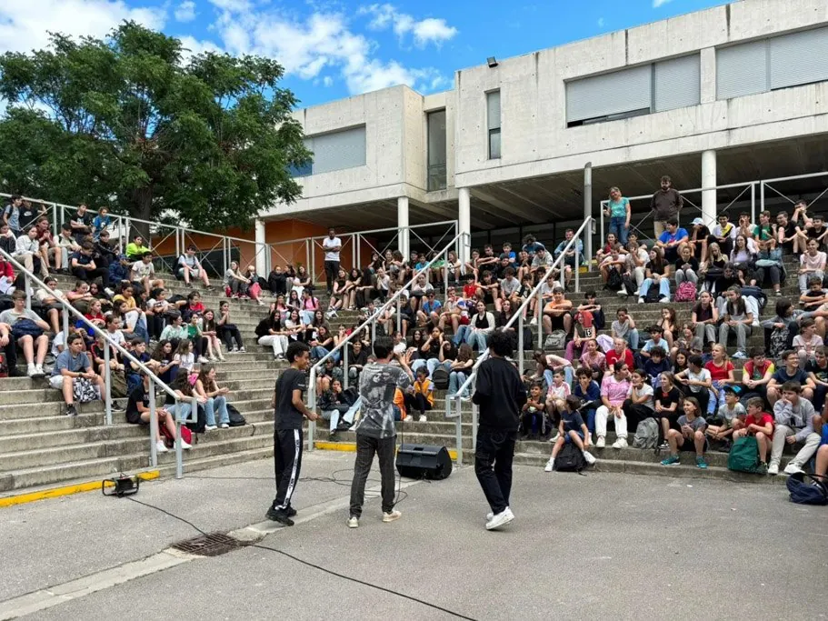 Trois jeunes en performance devant tout l'établissement, dans la cour